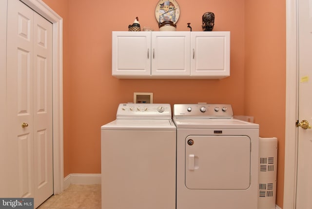 laundry room with cabinets, separate washer and dryer, and light tile patterned flooring