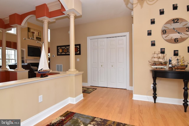 foyer with hardwood / wood-style floors and ornate columns