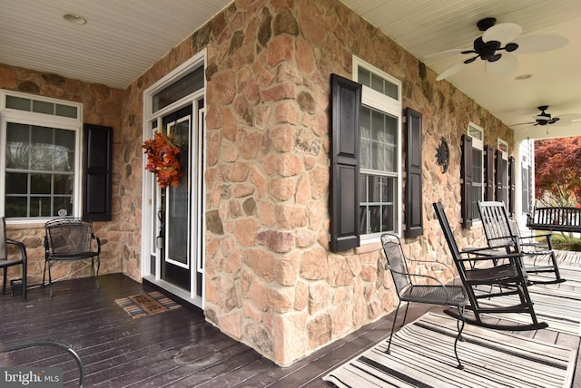 wooden terrace featuring ceiling fan and a porch