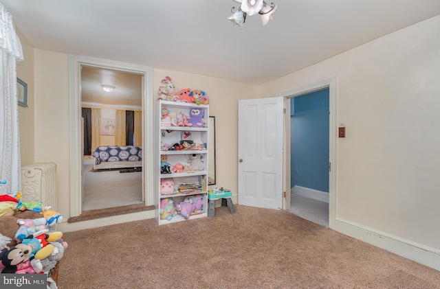 recreation room with radiator heating unit and carpet