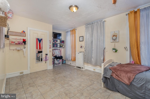 tiled bedroom featuring a textured ceiling and radiator