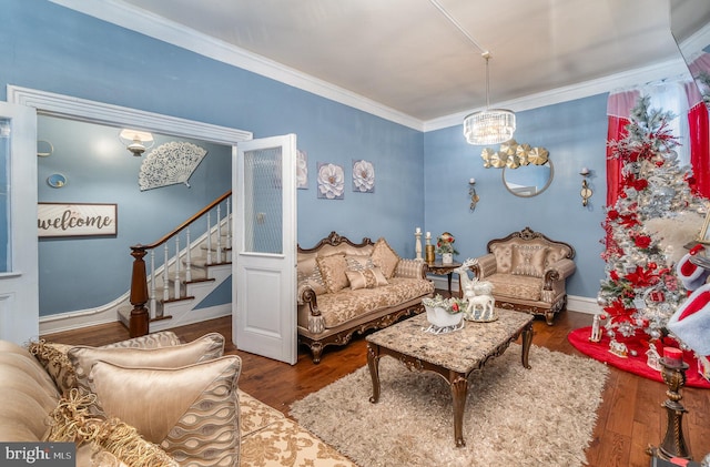 living room featuring wood-type flooring, ornamental molding, and a notable chandelier