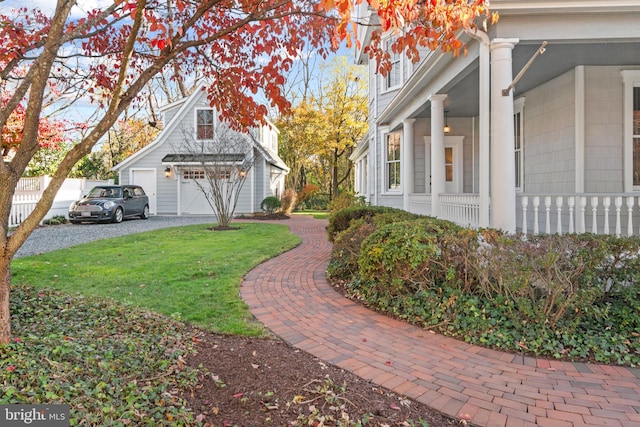 view of yard with covered porch and a garage