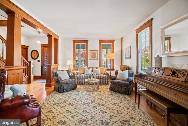 living room featuring light wood-type flooring and decorative columns