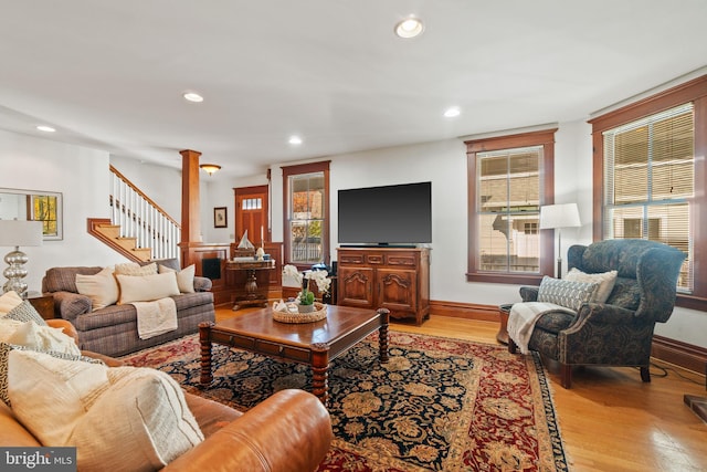 living room featuring decorative columns and light hardwood / wood-style flooring