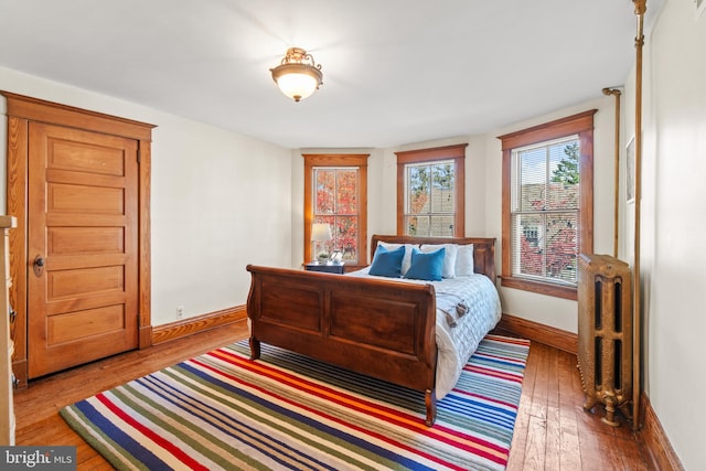 bedroom with wood-type flooring and radiator heating unit