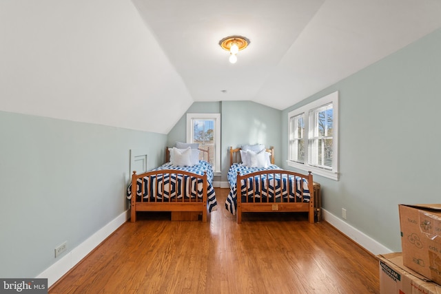 bedroom featuring hardwood / wood-style floors and lofted ceiling