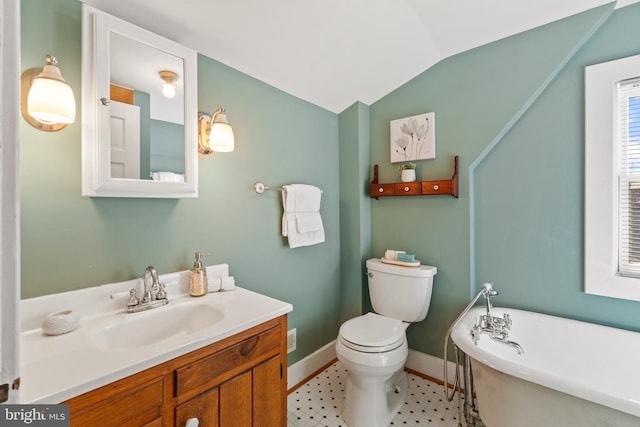 bathroom with toilet, vanity, vaulted ceiling, and a bathtub