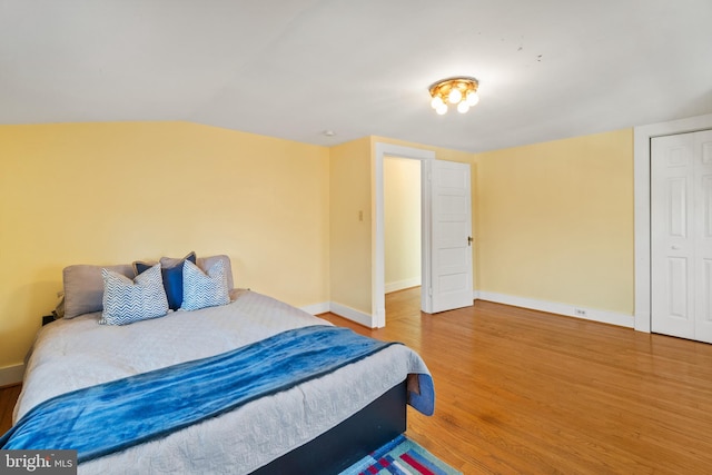 bedroom featuring hardwood / wood-style flooring and vaulted ceiling