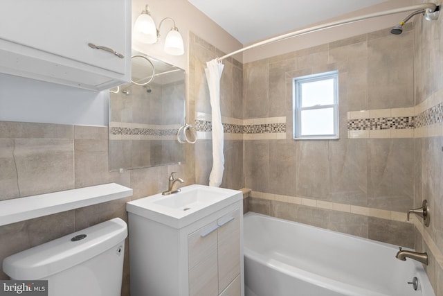 full bathroom featuring tile walls, vanity, shower / tub combo, and toilet