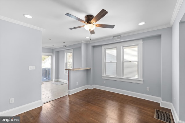 unfurnished room featuring hardwood / wood-style flooring, plenty of natural light, ceiling fan, and ornamental molding