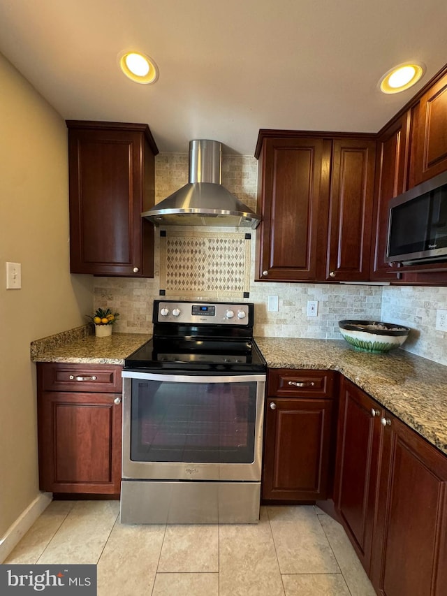 kitchen with backsplash, wall chimney exhaust hood, light stone counters, and stainless steel appliances