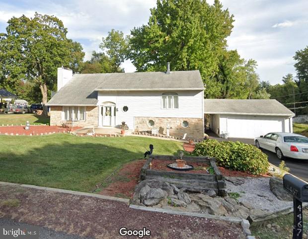 view of front of house with a garage and a front lawn