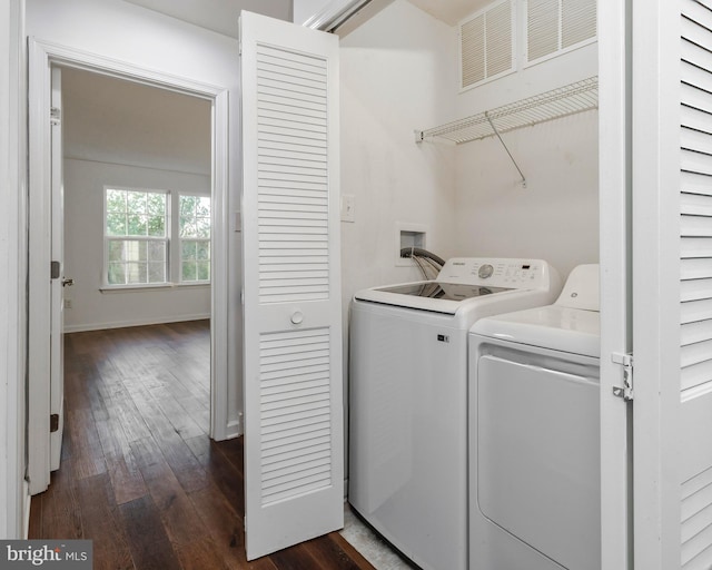 clothes washing area with washing machine and dryer and dark wood-type flooring