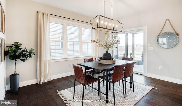 dining room with dark hardwood / wood-style flooring and an inviting chandelier