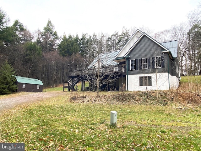 exterior space featuring an outdoor structure, a yard, and a wooden deck