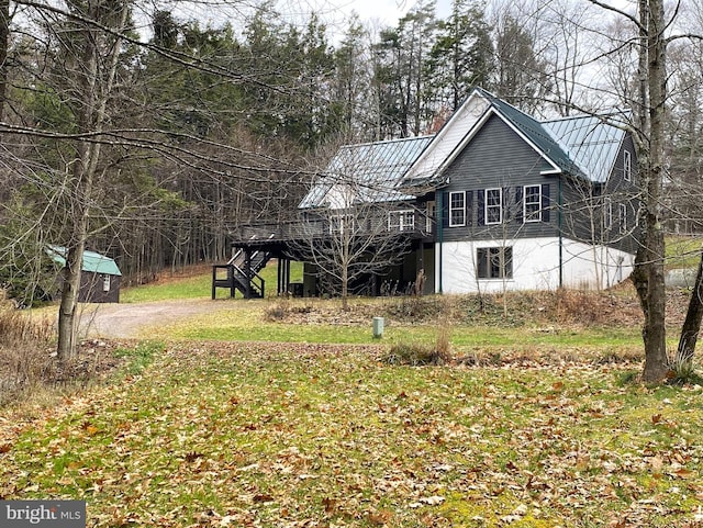 view of side of property featuring a lawn and a deck