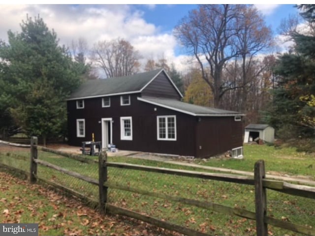 view of side of home featuring a storage shed and a lawn