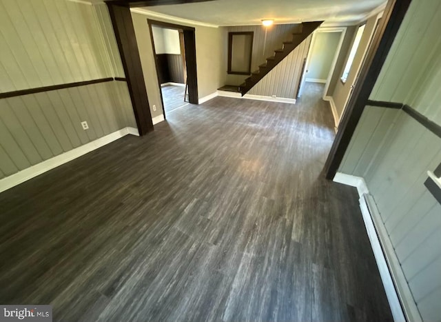 spare room with baseboard heating, wooden walls, and dark hardwood / wood-style flooring