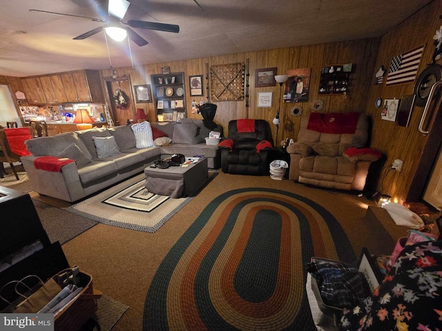 living room with wood walls, carpet, and ceiling fan