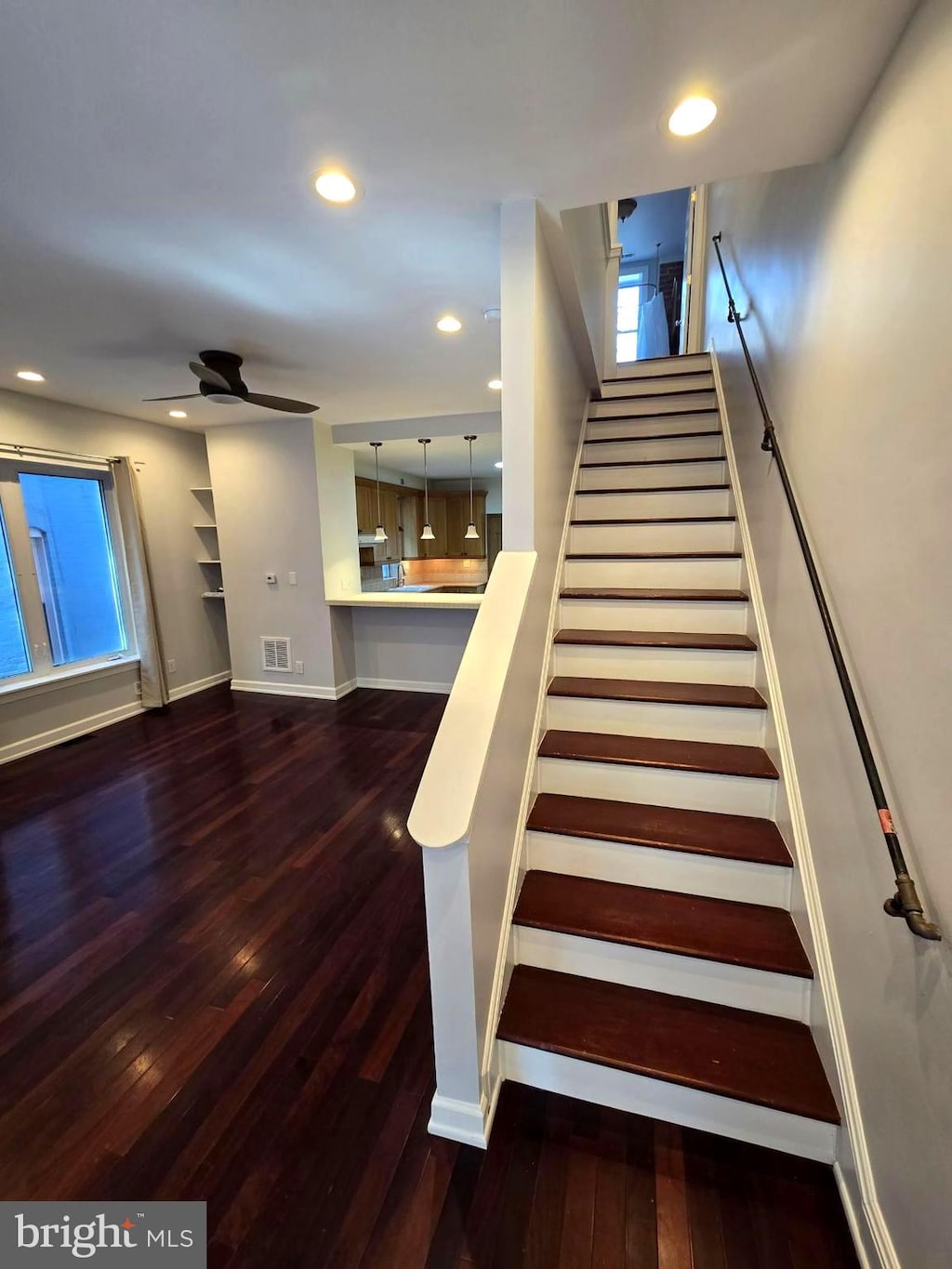 stairway with ceiling fan and hardwood / wood-style floors