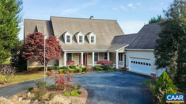 cape cod home featuring a porch and a garage