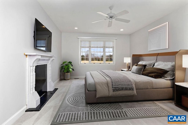 bedroom with ceiling fan and a fireplace