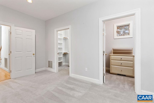 carpeted bedroom featuring a spacious closet and a closet