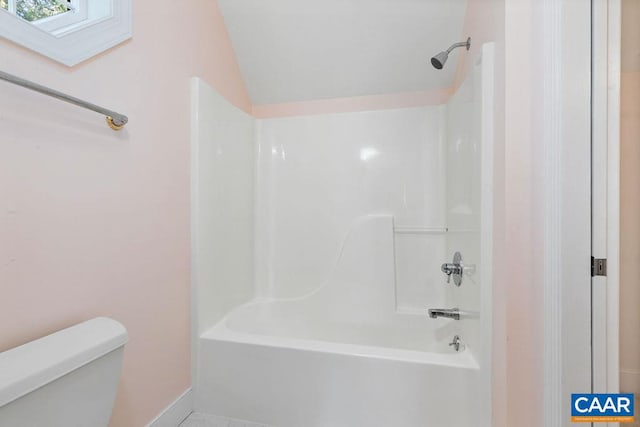 bathroom featuring bathing tub / shower combination, lofted ceiling, and toilet