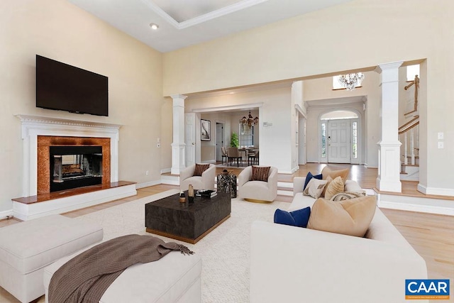 living room featuring hardwood / wood-style flooring, a towering ceiling, and a chandelier