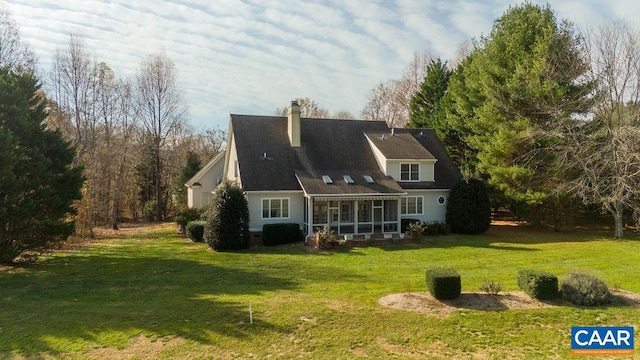 back of property featuring a yard and a sunroom