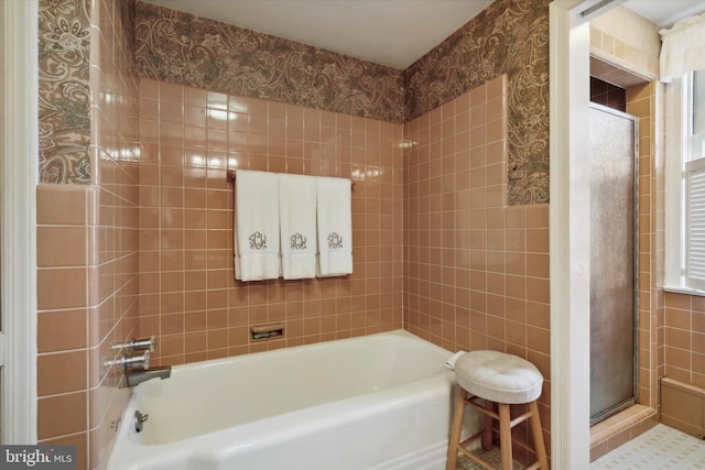 bathroom featuring plus walk in shower and tile walls