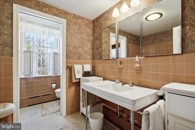 bathroom with baseboard heating, tile patterned flooring, tile walls, and toilet