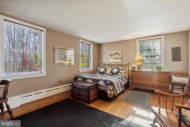 bedroom featuring hardwood / wood-style flooring and a baseboard radiator