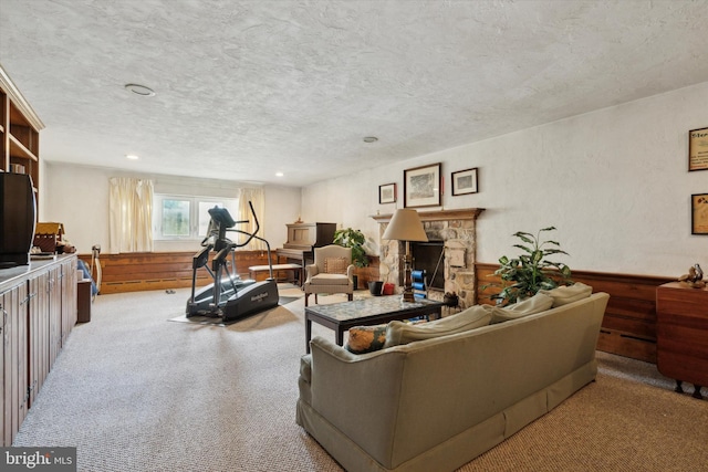 living room with a fireplace, a textured ceiling, and light carpet