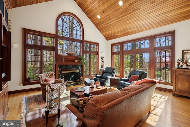 living room featuring a healthy amount of sunlight, high vaulted ceiling, wood ceiling, and light wood-type flooring