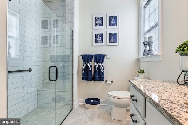 bathroom featuring vanity, toilet, and a shower with door