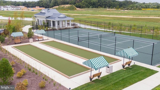 view of property's community with tennis court and a water view