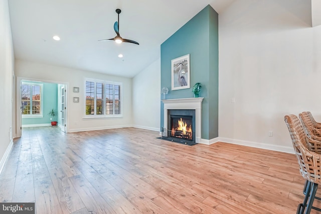 unfurnished living room featuring ceiling fan, light hardwood / wood-style flooring, and vaulted ceiling