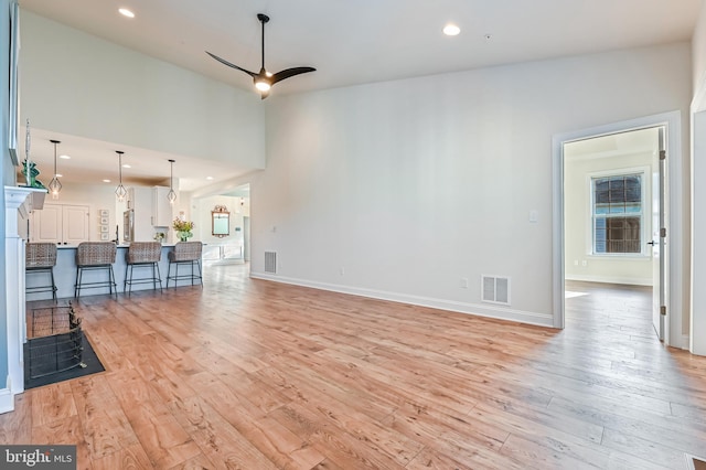 unfurnished living room with light hardwood / wood-style flooring, ceiling fan, and plenty of natural light