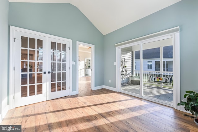 doorway to outside featuring french doors, high vaulted ceiling, plenty of natural light, and wood-type flooring