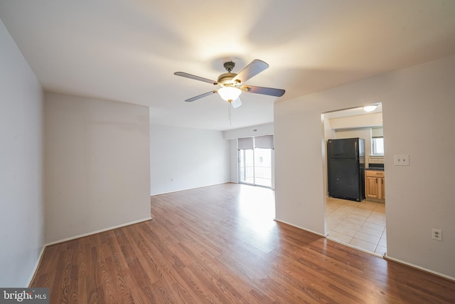 unfurnished room with a wealth of natural light, ceiling fan, and light hardwood / wood-style floors