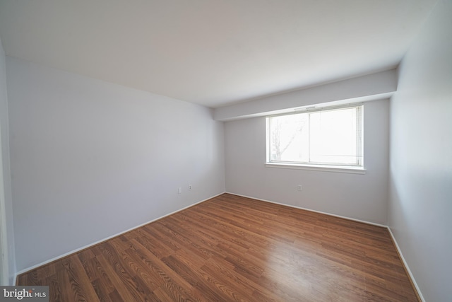 spare room featuring dark wood-type flooring