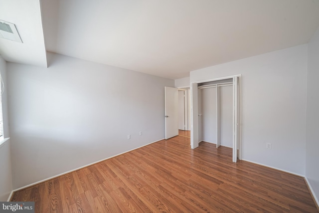 unfurnished bedroom with hardwood / wood-style flooring and a closet