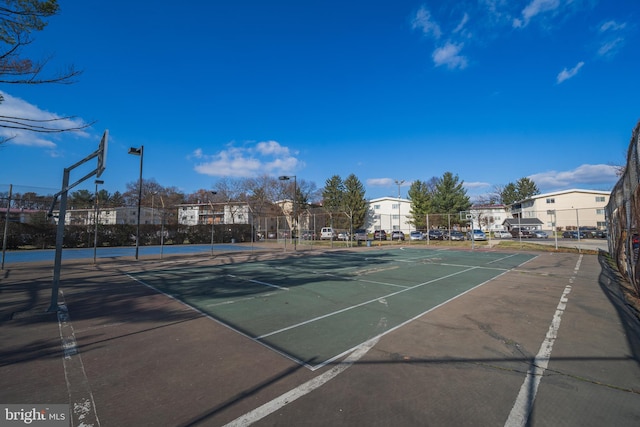 view of tennis court featuring basketball hoop