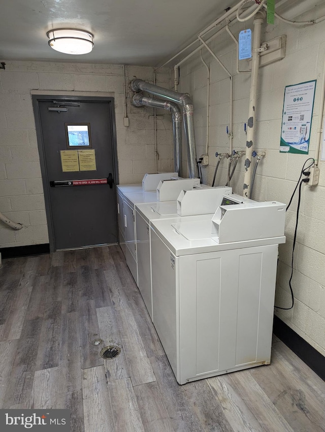 clothes washing area with hardwood / wood-style flooring and separate washer and dryer