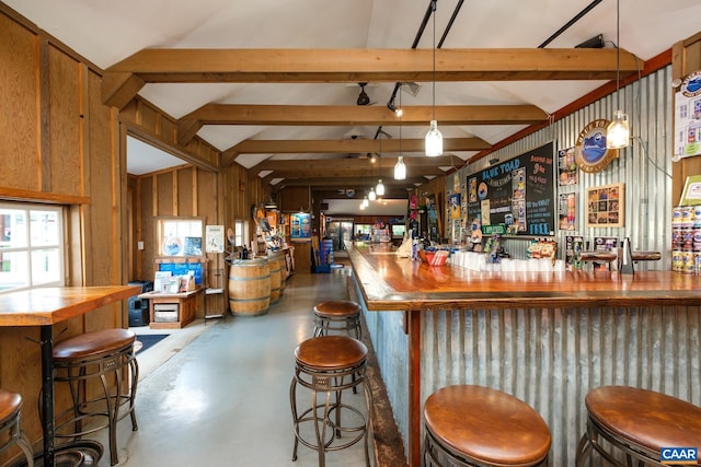 bar with pendant lighting, lofted ceiling with beams, and wood walls