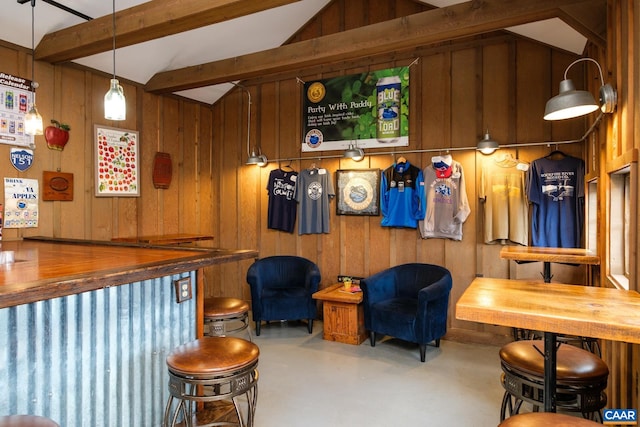 bar with butcher block counters, wood walls, lofted ceiling with beams, and decorative light fixtures