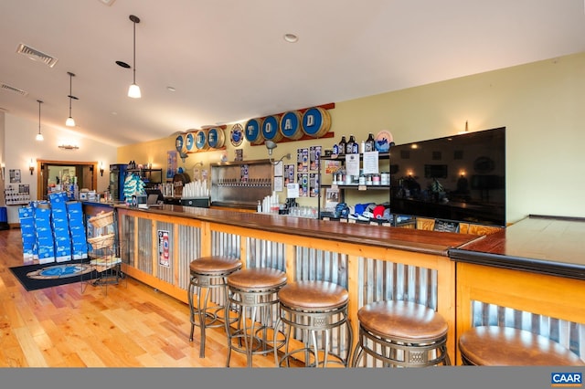 bar with hardwood / wood-style floors and vaulted ceiling