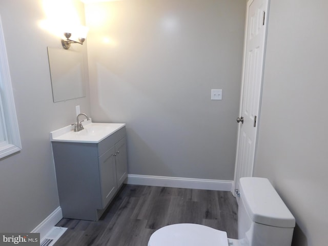 bathroom with vanity, toilet, and wood-type flooring